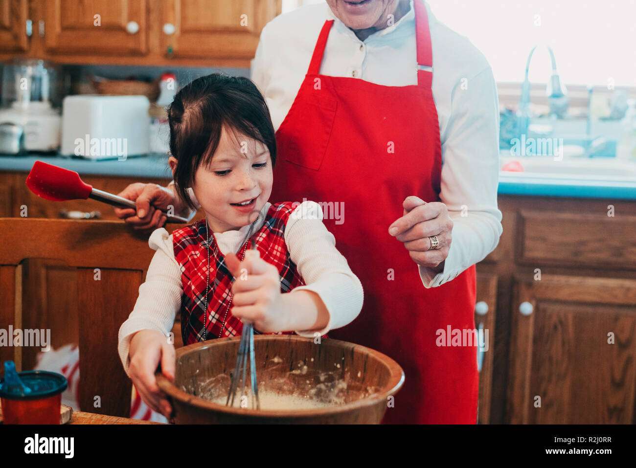 Grandmother teaching her granddaughter to bake Stock Photo