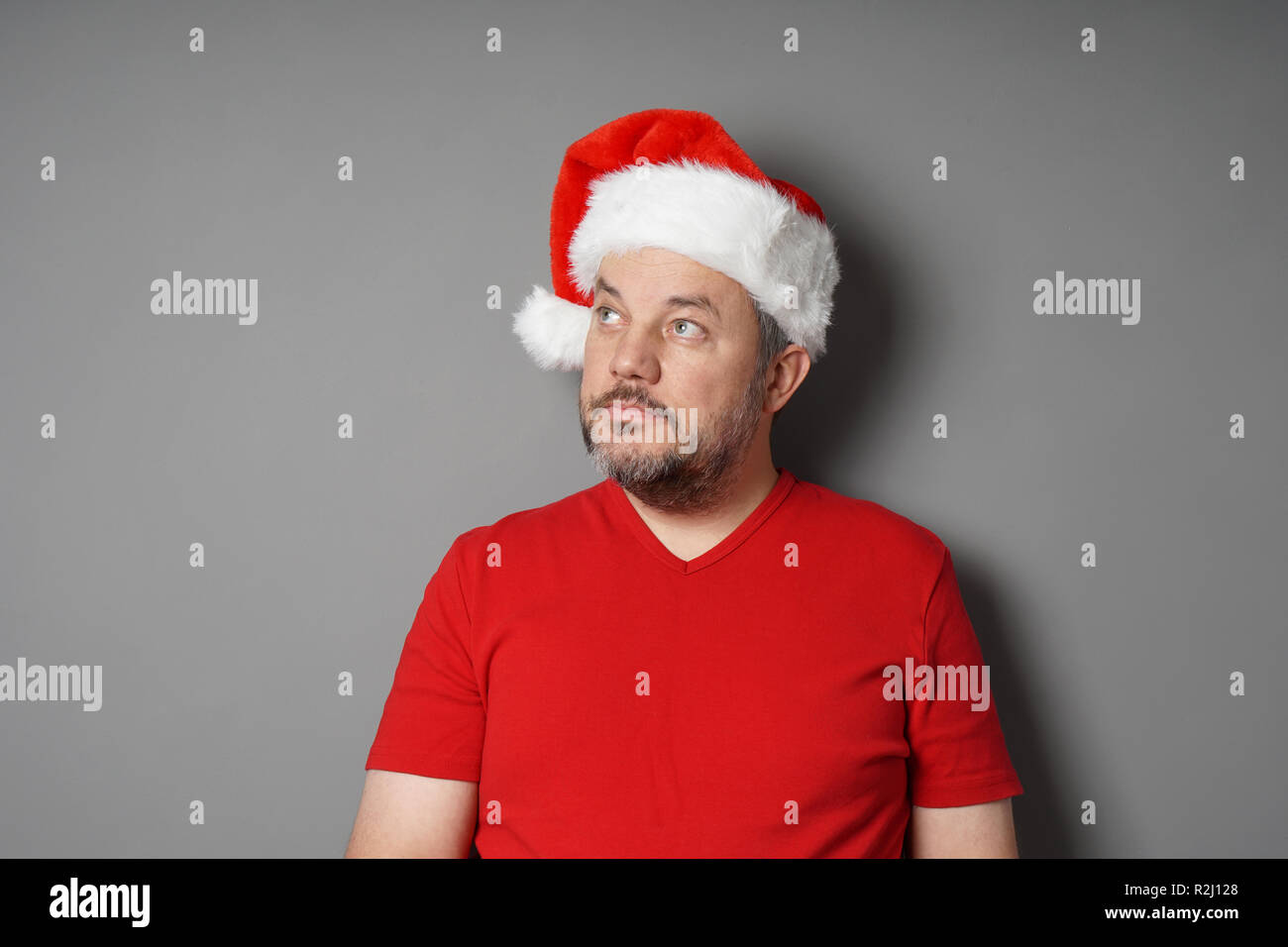 man wearing santa hat looking up to copy space Stock Photo