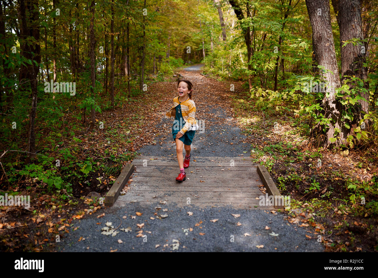 Girl running across a small footbridge, United States Stock Photo