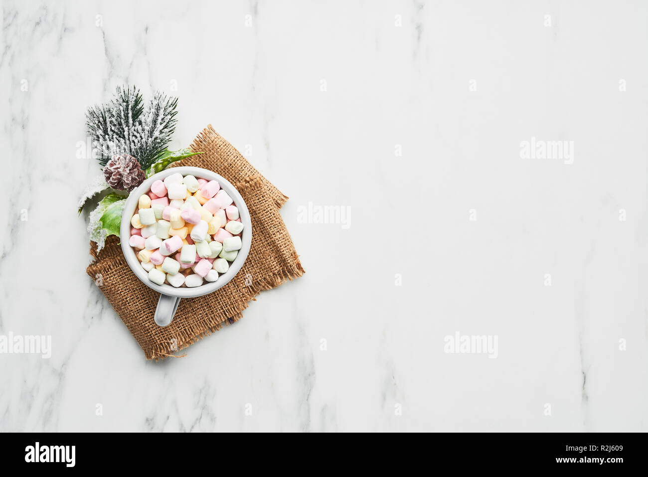 Cup of traditional Christmas hot chocolate or cocoa with marshmallow. Top view, white marble table, copy space. Stock Photo