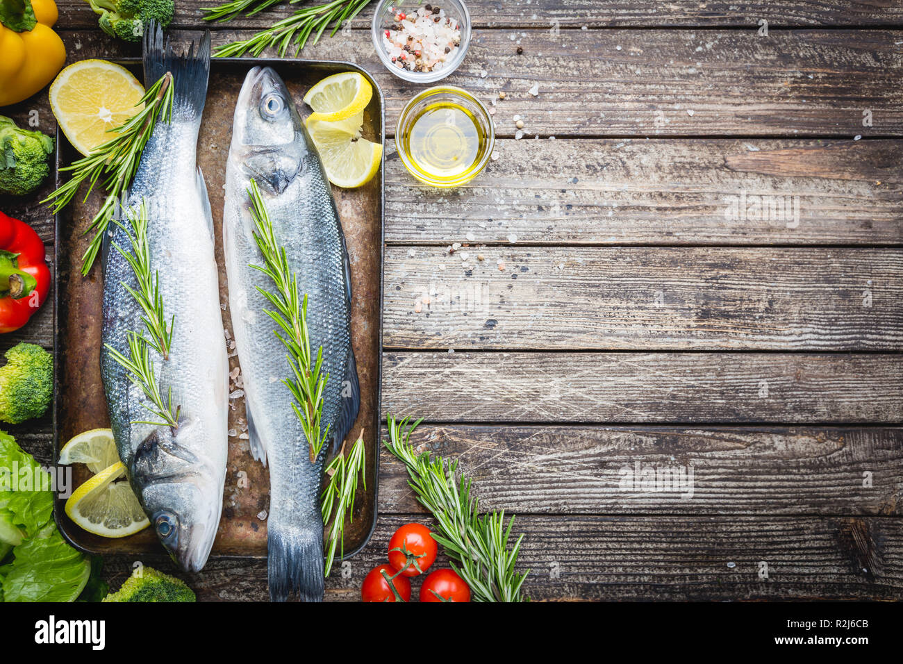 Fresh raw seabass and ingredients for cooking. Two fish seabass with