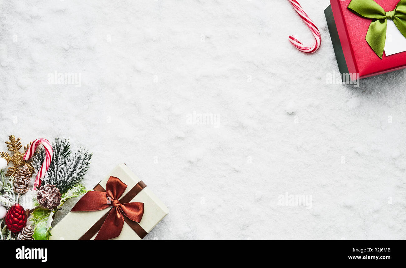 Top view of wrapped Christmas gift boxes with ribbons and decoration on the snow. Copy space for text. Stock Photo