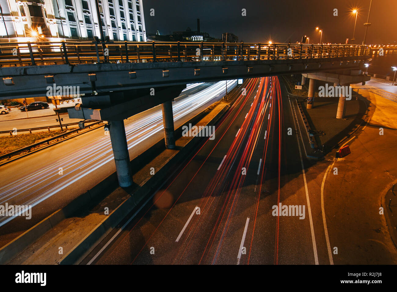 Transportation highway system with long exposure in dusk, shoted in Kyiv, Ukraine. Car trails on busy road. Stock Photo