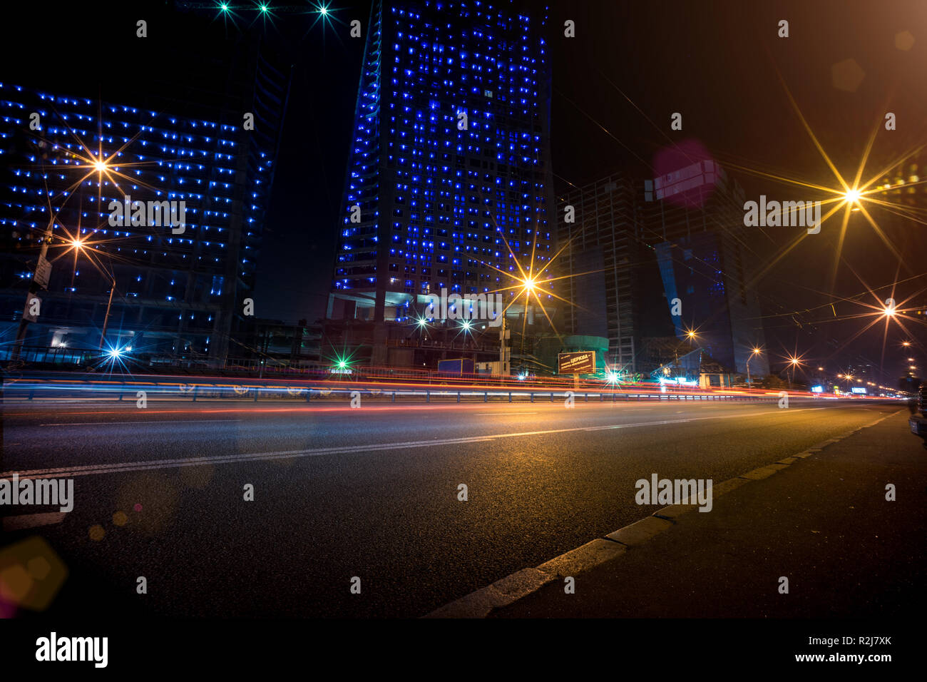 Kyiv night car trails on the modern building background, ukraine Stock Photo