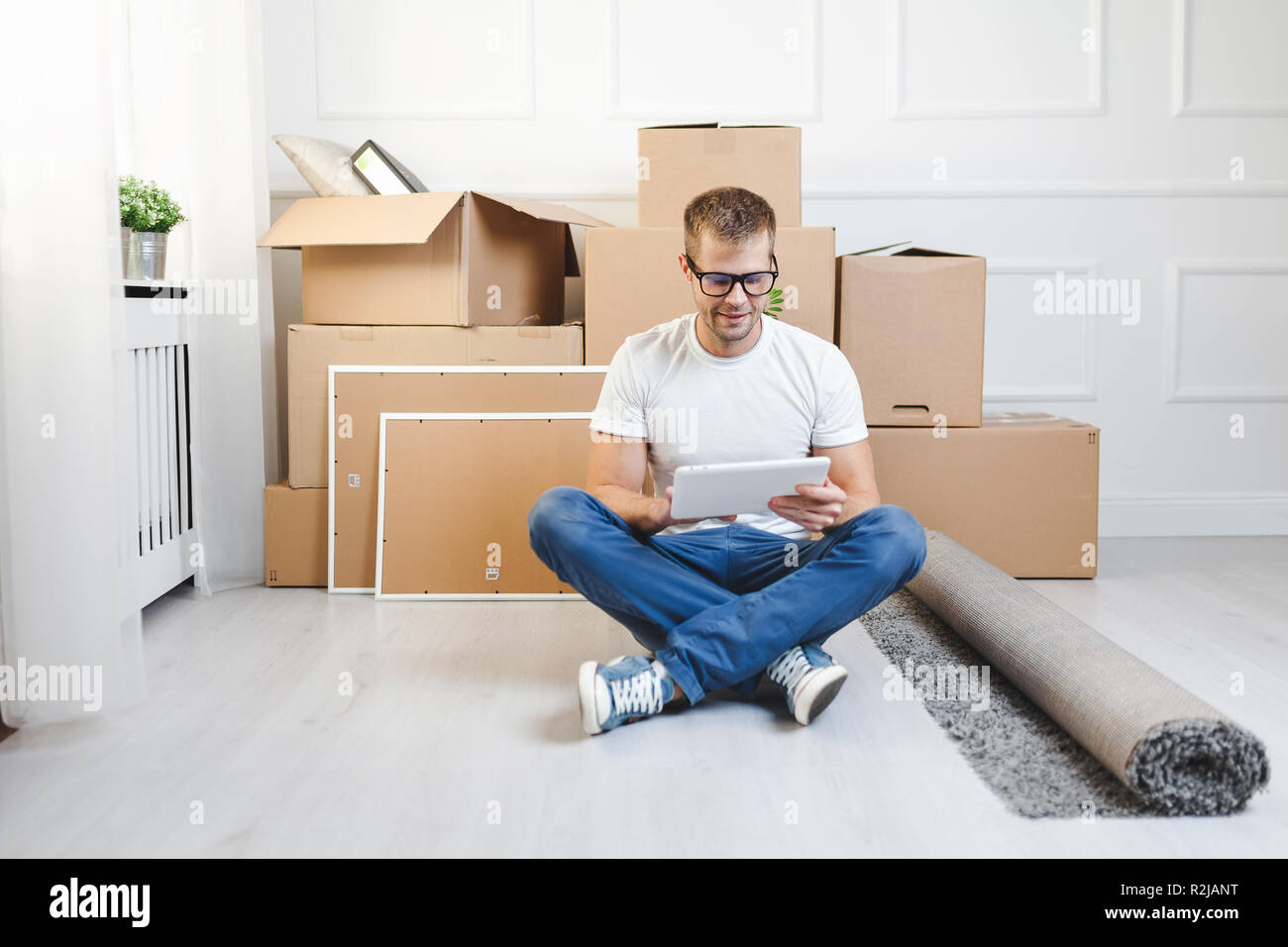 Handsome young man moving into his new home Stock Photo