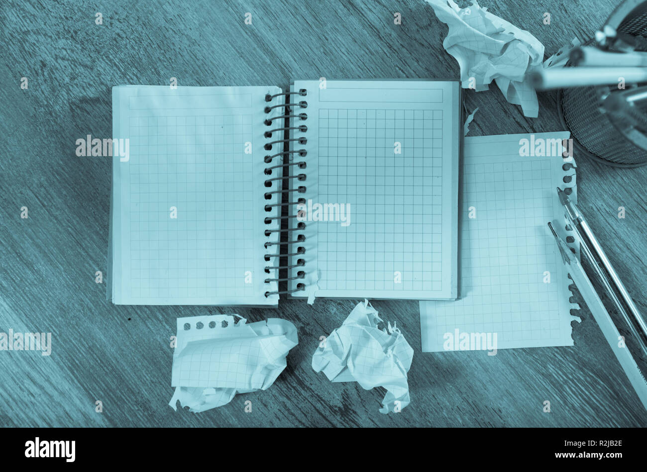 Crumpled empty pages and notebook lying on wooden surface Stock Photo
