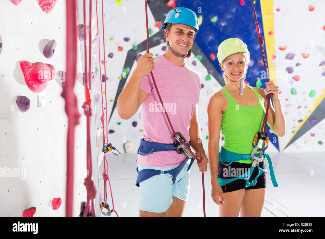 Two smiling confident athletes in climbing outfit ready for workout at bouldering gym Stock