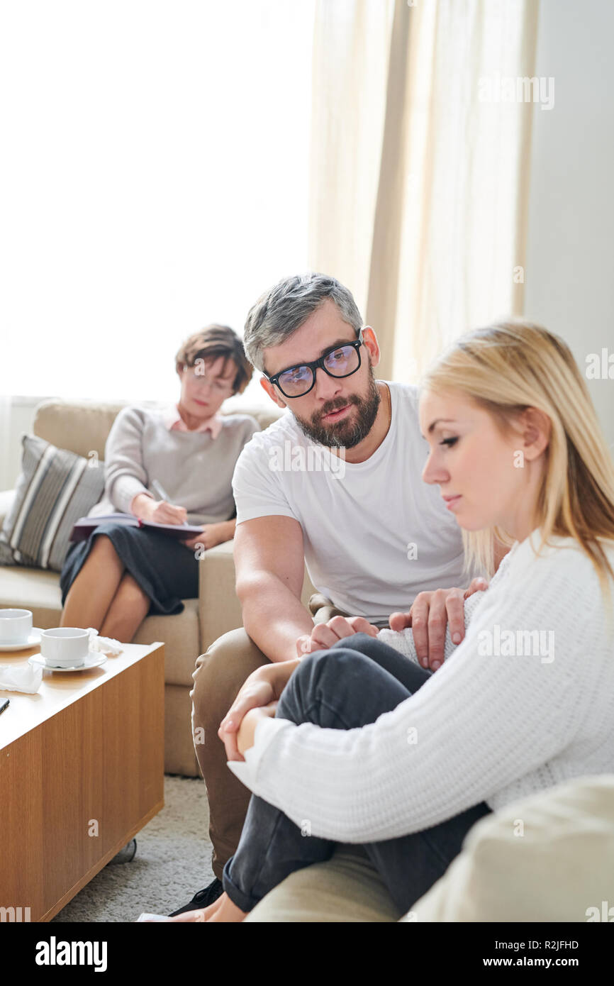 Young wife feeling sorrow at therapy session Stock Photo