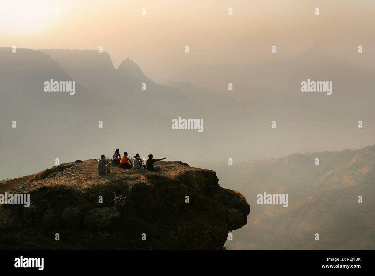 group of people sitting in front of mountain landscape Stock Photo