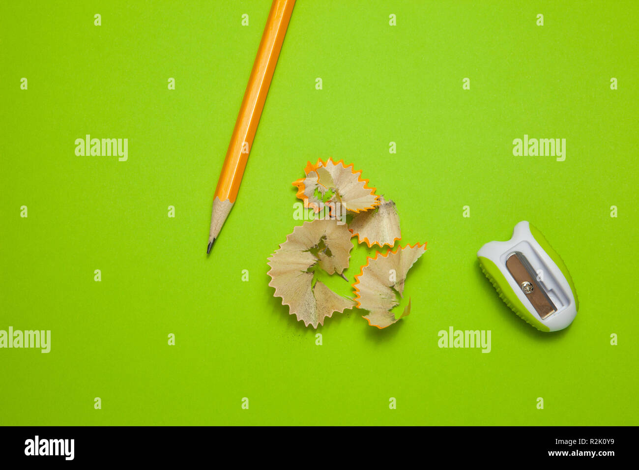 Sharpened pencil and sharpener on green background, top view Stock Photo