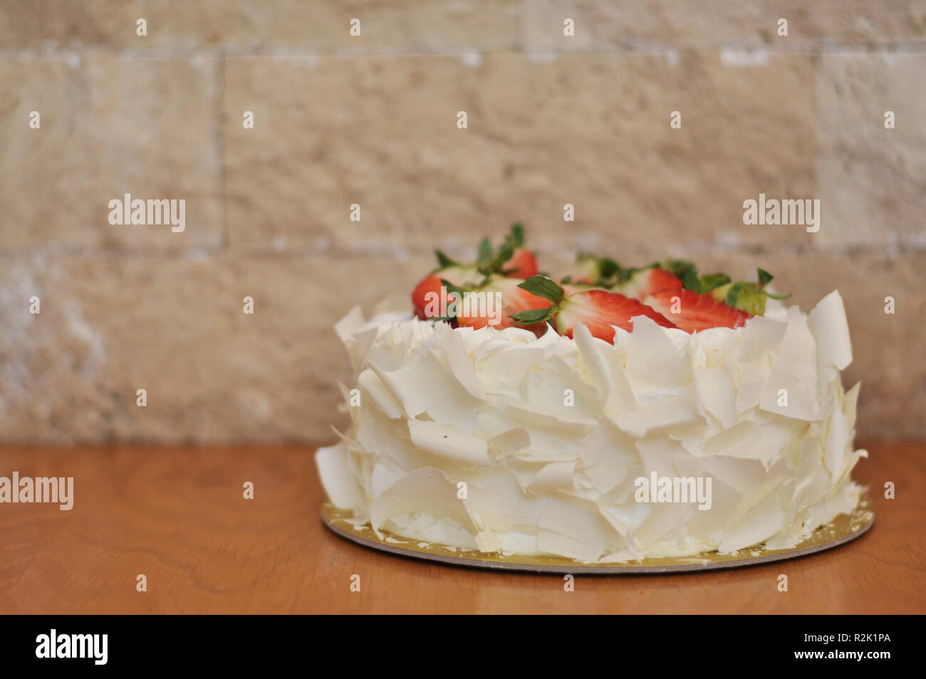White chocolate strawberry cake with fresh strawberry fruits on top and white chocolate pieces around Stock Photo
