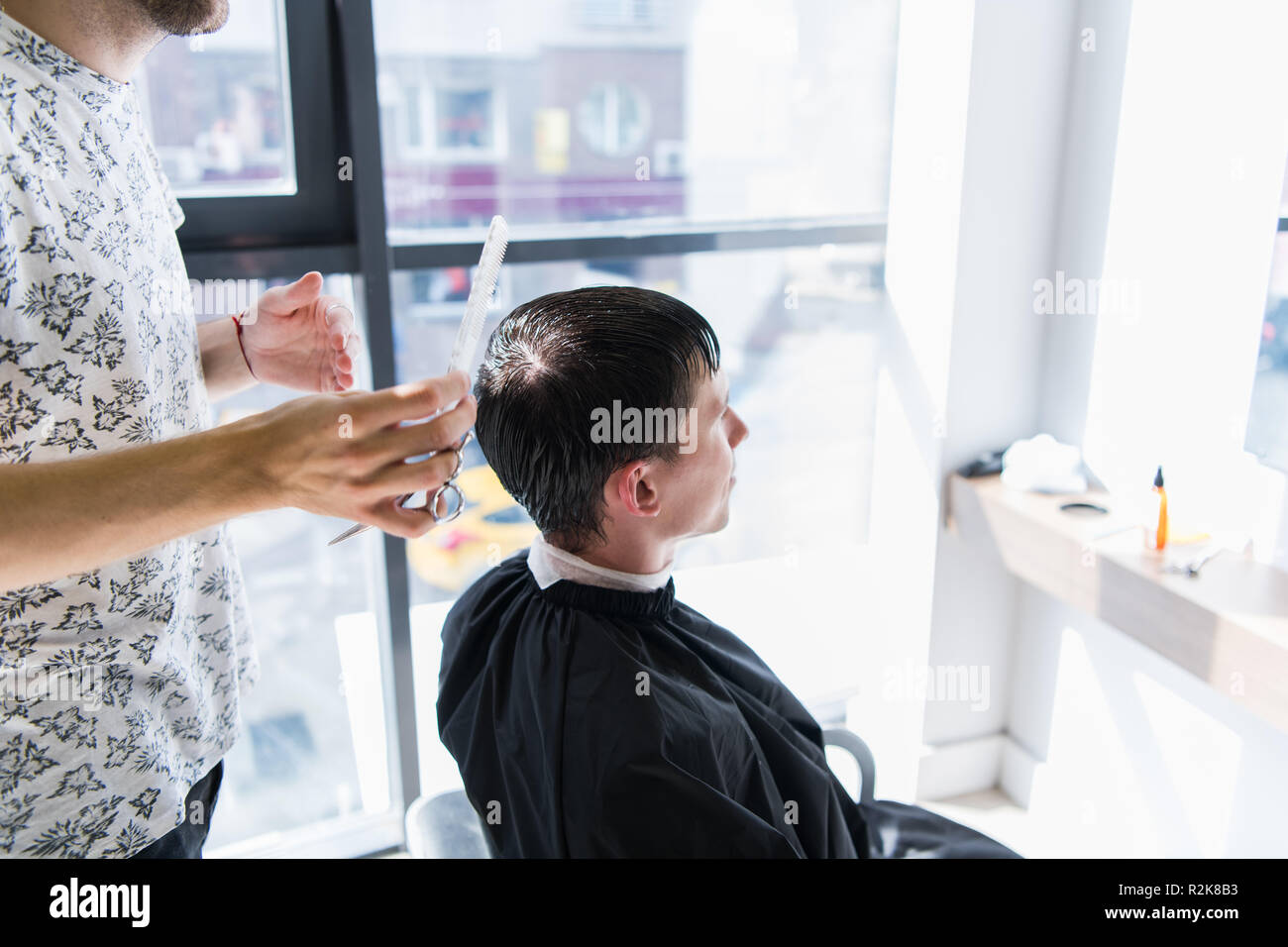 A Professional Hairstylist With A Comb And Scissors In His Hand