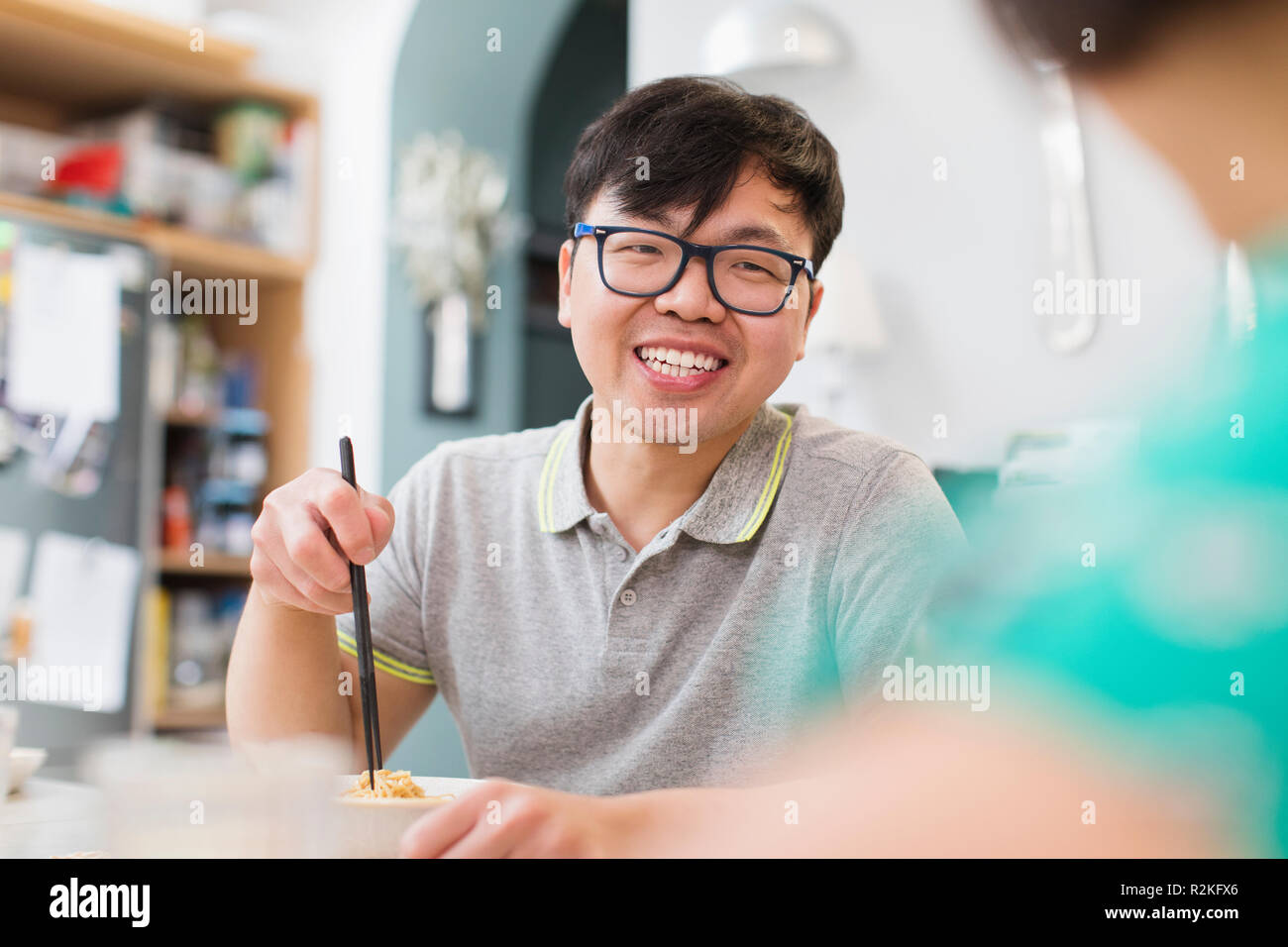 Happy man eating noodles with chopsticks Stock Photo