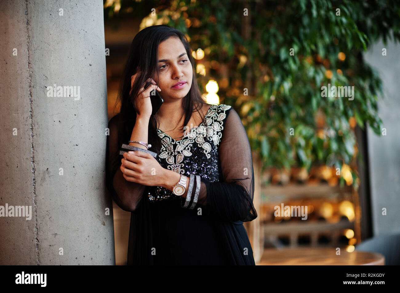 Pretty indian girl in black saree dress posed at restaurant with mobile  phone at hand Stock Photo - Alamy