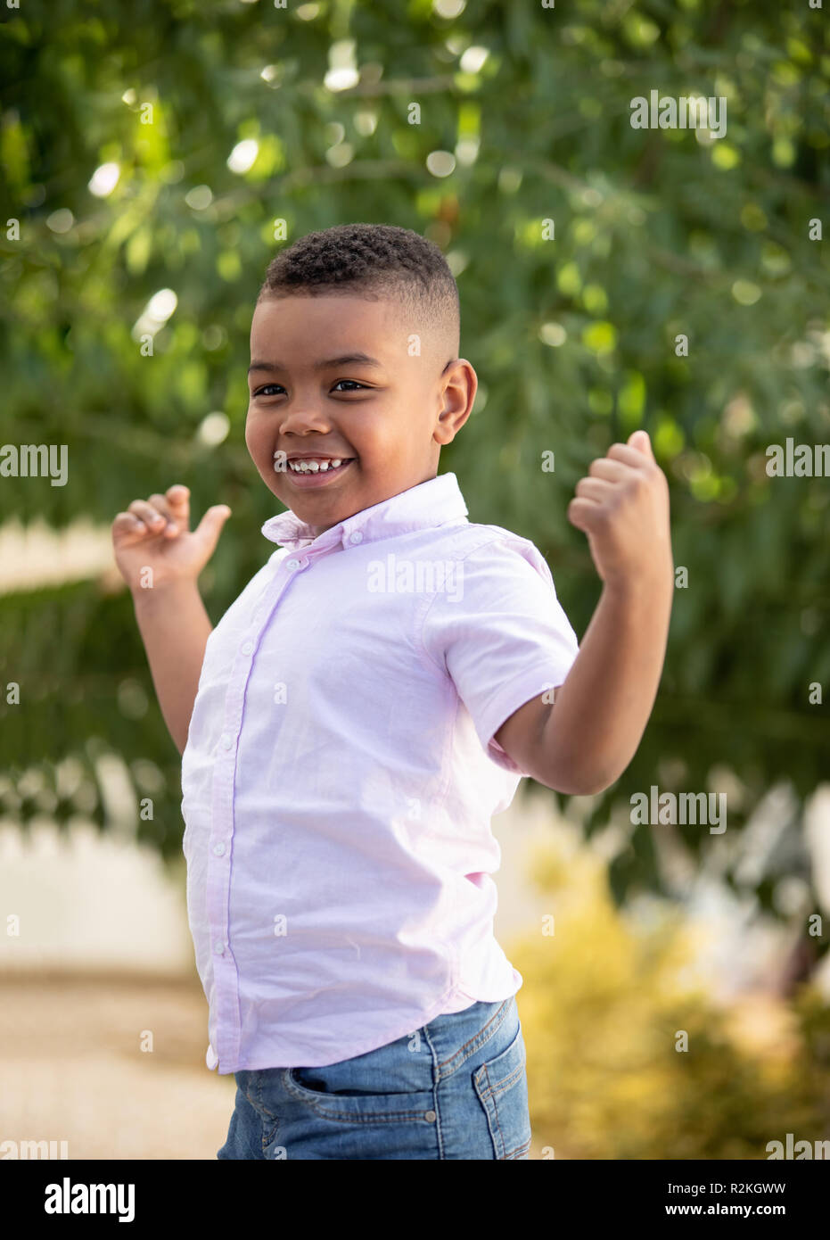 Strong latin boy in the park showing his muscles Stock Photo