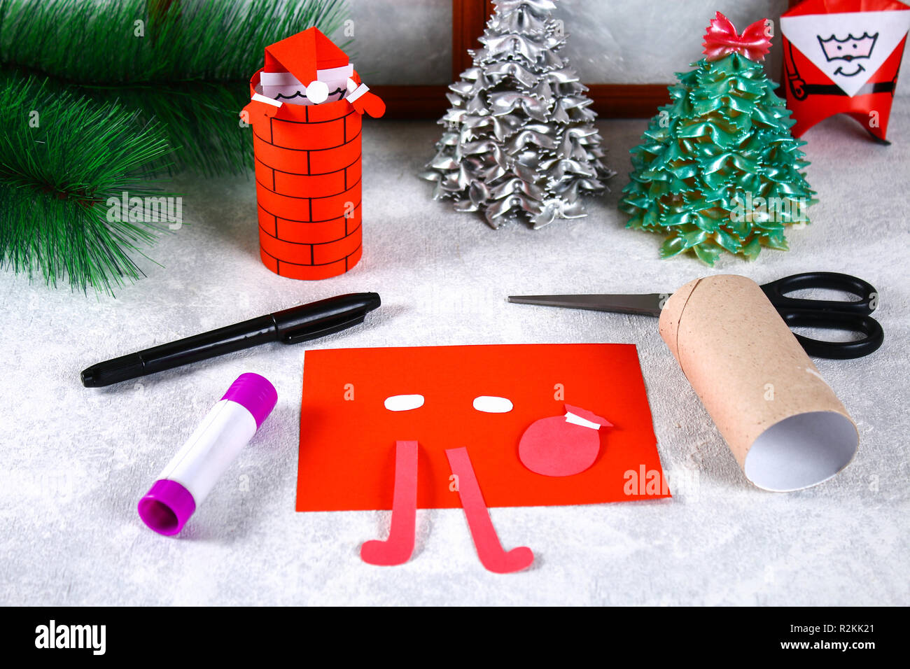 Christmas Santa Claus in chimney made from toilet paper hub, colored paper,  marker, glue, fishing line and cotton pad. DIY toy on the Christmas tree  Stock Photo - Alamy