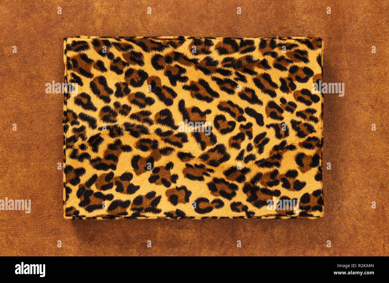 Storage box with vintage leopard print, on brown leather background