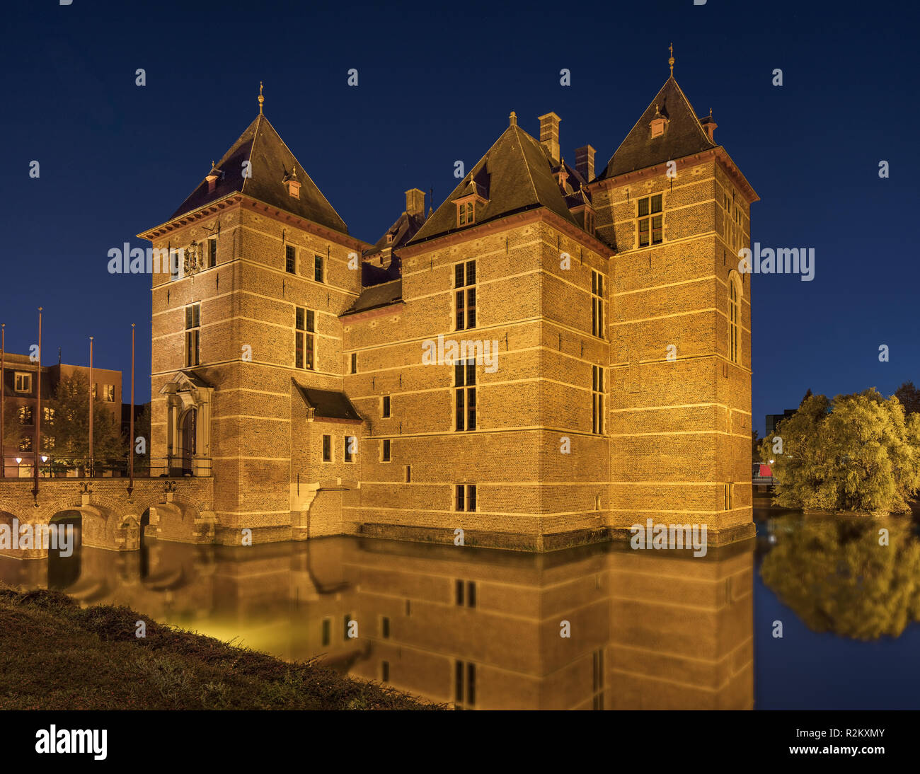 Illuminated 12th Century renovated Castle surrounded by water at night, Europe. Stock Photo