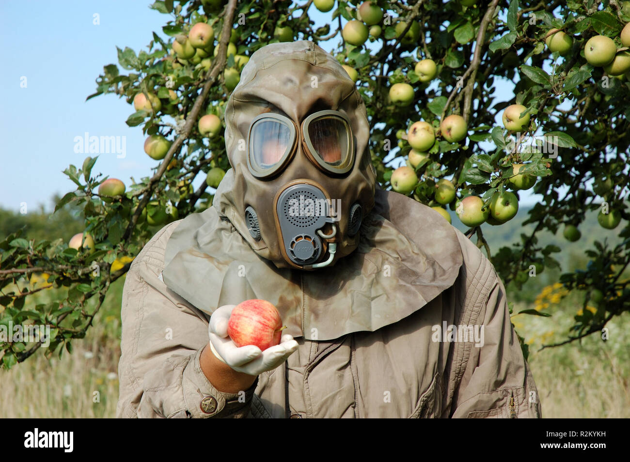 man with gas mask holding an apple Stock Photo