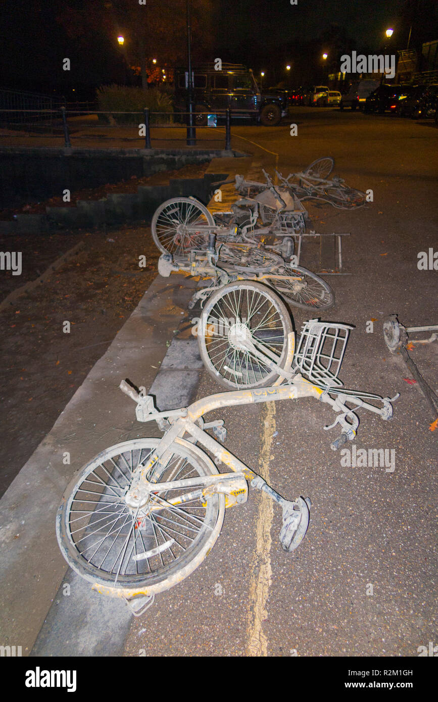 Collection of OFO bicycles dock less / dockless cycles / bike / Boris bikes which have been dredged up from the River Thames at Twickenham shown at night. UK Stock Photo