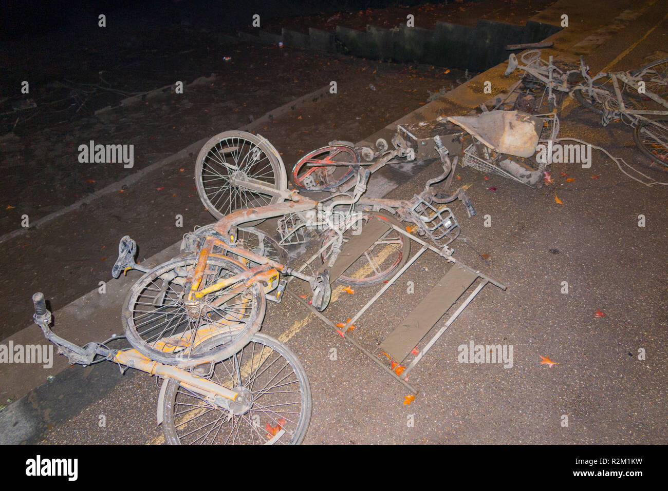 Collection of OFO bicycles dock less / dockless cycles / bike / Boris bikes which have been dredged up from the River Thames at Twickenham shown at night. UK Stock Photo