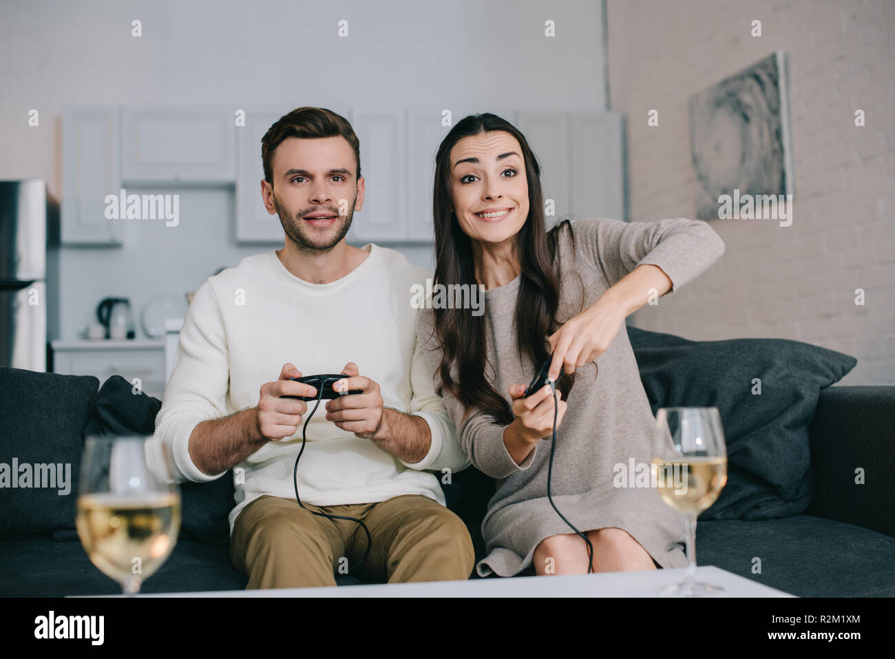 happy young couple playing retro video game on couch at home Stock Photo