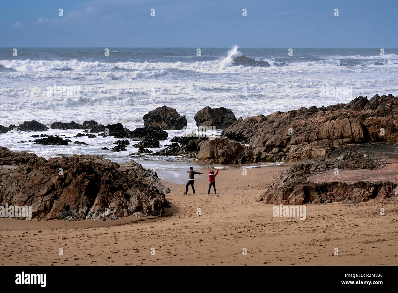 a couple doing exercise at the sea shore in a day of stormy waters, practicing the healthy lifestyle. zen mood Stock Photo