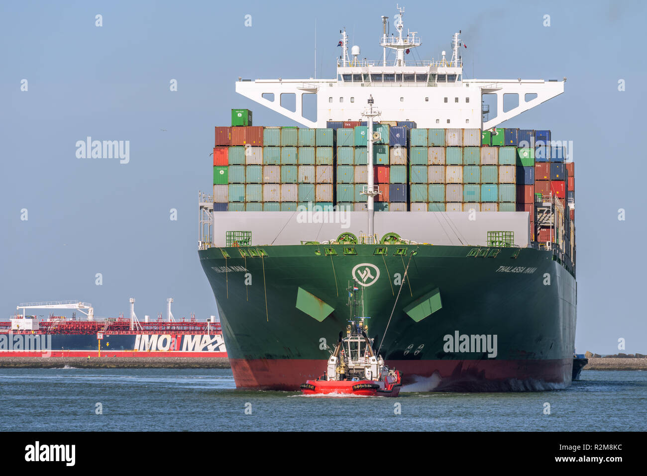 ROTTERDAM, THE NETHERLANDS - FEBRUARY 16, 2018: The large container ship Thalassa Mana is escorted by a tug at its arrival at the Maasvlakte, Port of  Stock Photo