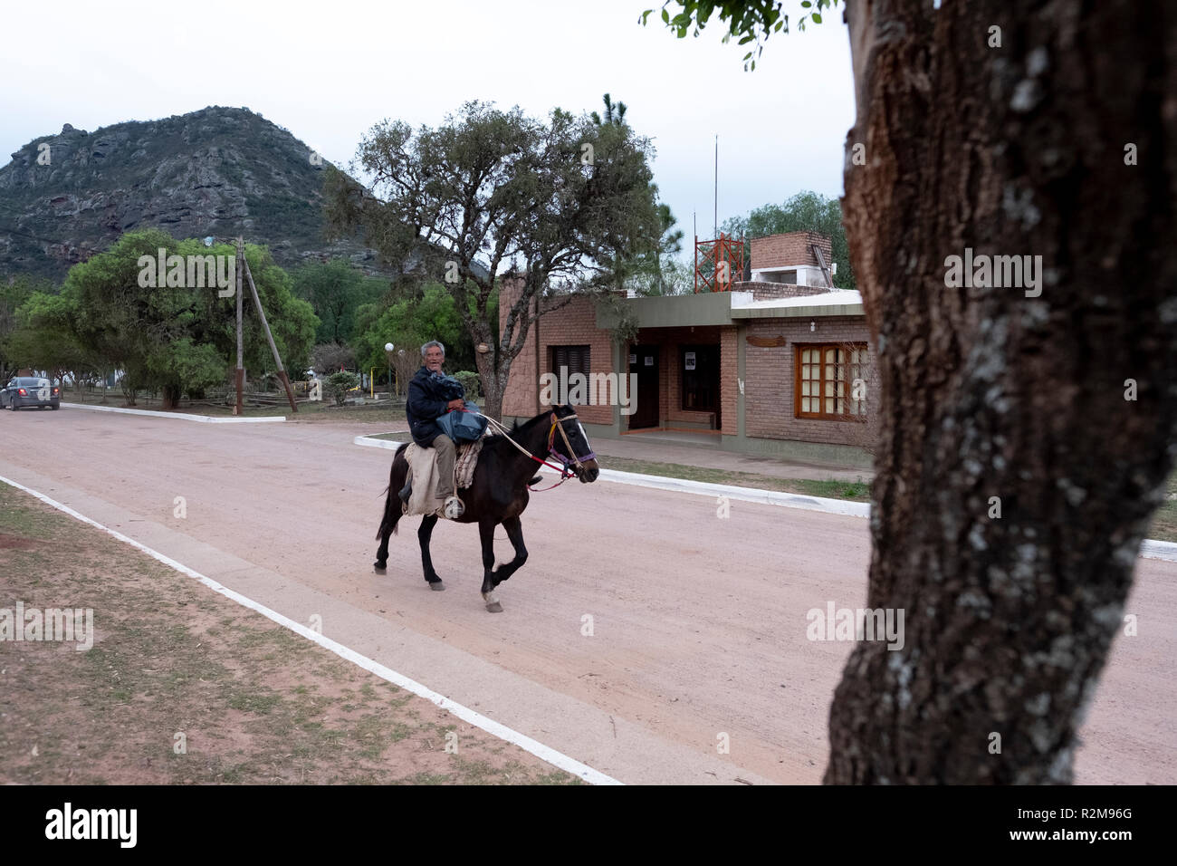 A horseman rides through the small village of Cerro Colorado in Córdoba, Argentina Stock Photo