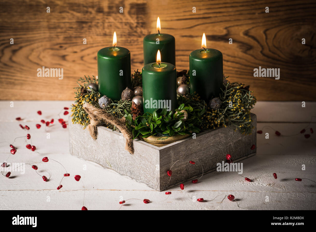 modern Advent arrangement with lit candles on wooden table Stock Photo