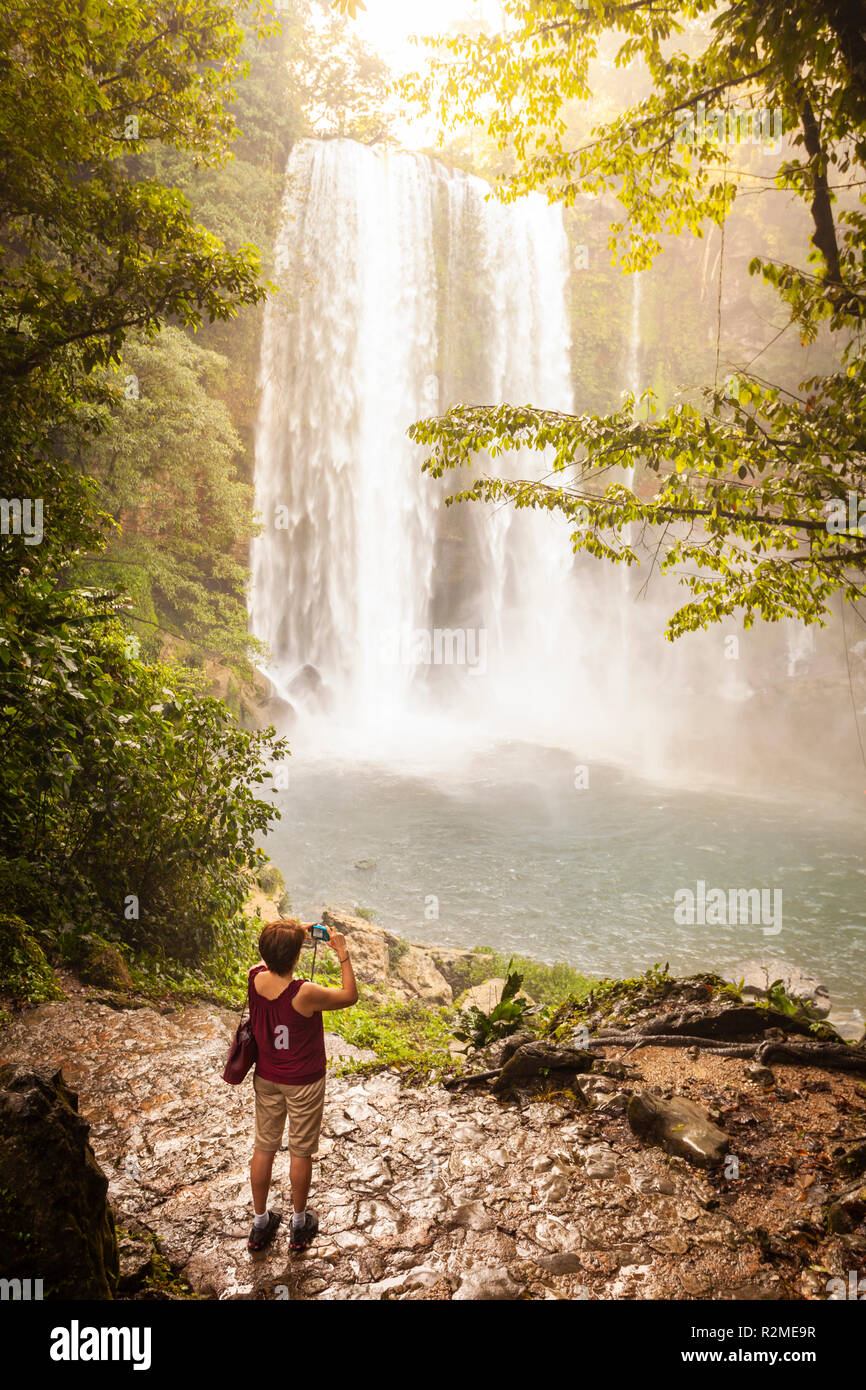A tourist photographs the misty Misol Ha waterfalls in Chiapas, Mexico. Stock Photo