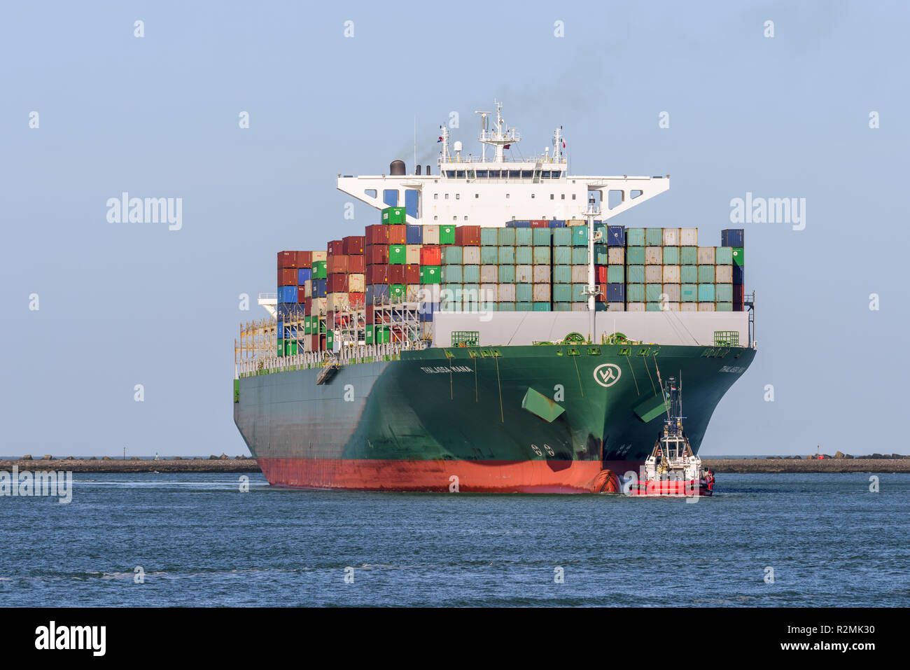 ROTTERDAM, THE NETHERLANDS - FEBRUARY 16, 2018: The large container ship Thalassa Mana is escorted by a tug, as it arrives at the Maasvlakte, Port of  Stock Photo
