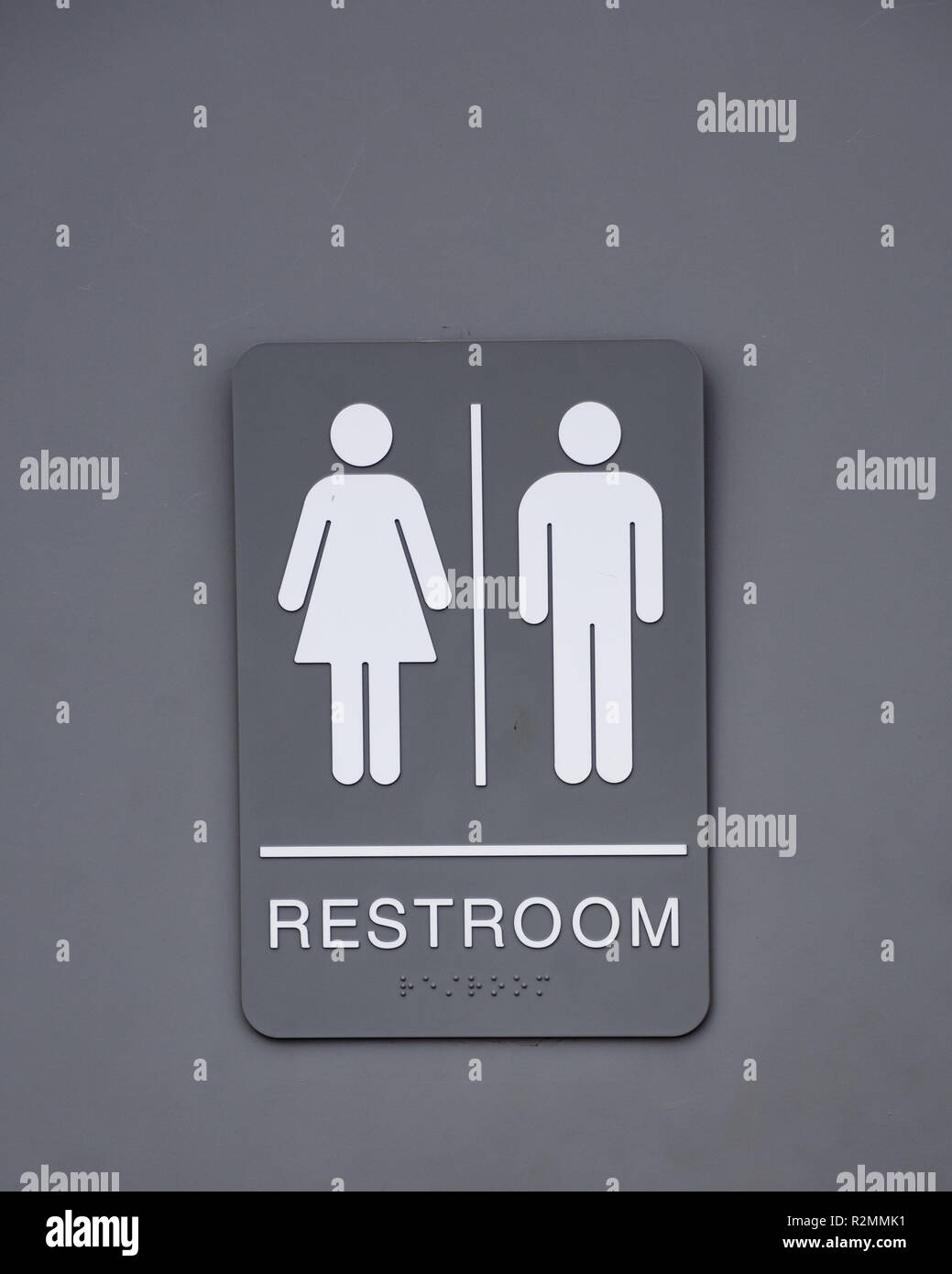 A gray and white unisex restroom sign on a bathroom door. Stock Photo