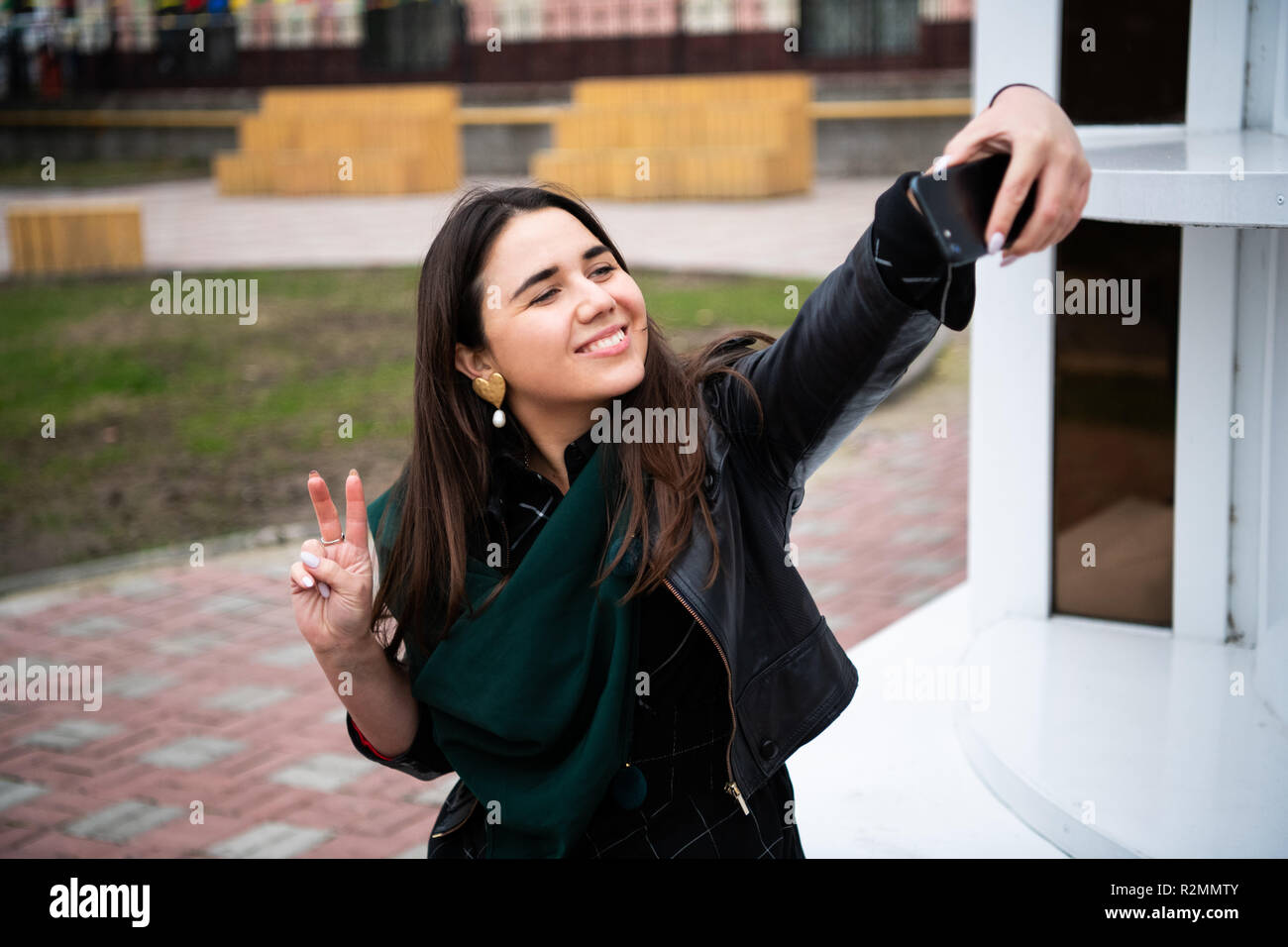 Happy young woman taking selfie with peace sign on city street Stock ...