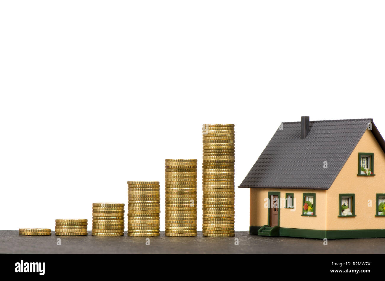 Symbol house purchase with model house and coin stack Stock Photo