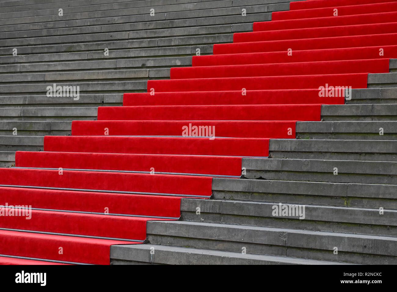 Close up red carpet over grey concrete stairs perspective ascending, low angle view Stock Photo