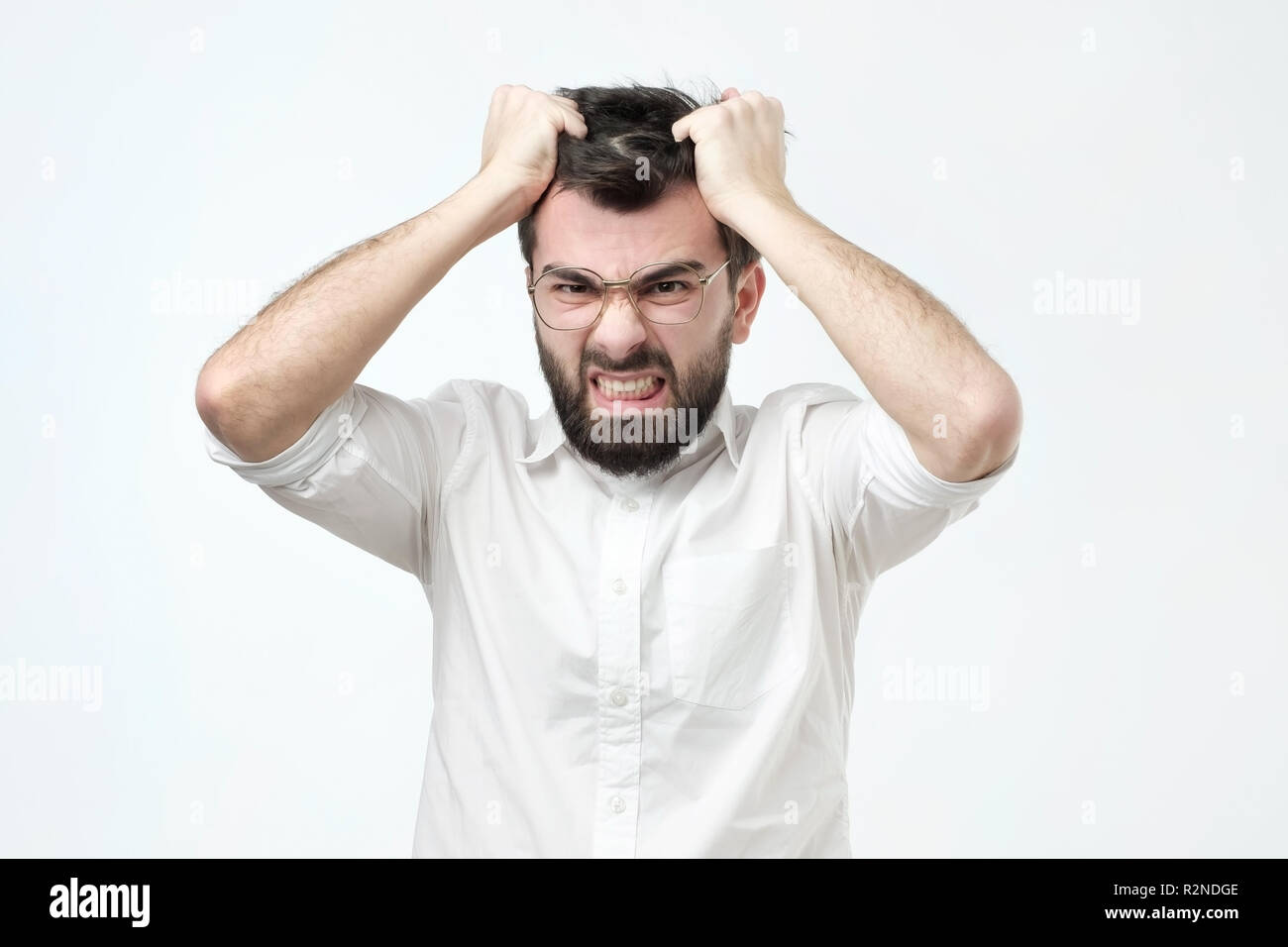 Angry spanish man pulling out his hair, being mad looking with furious expression Stock Photo