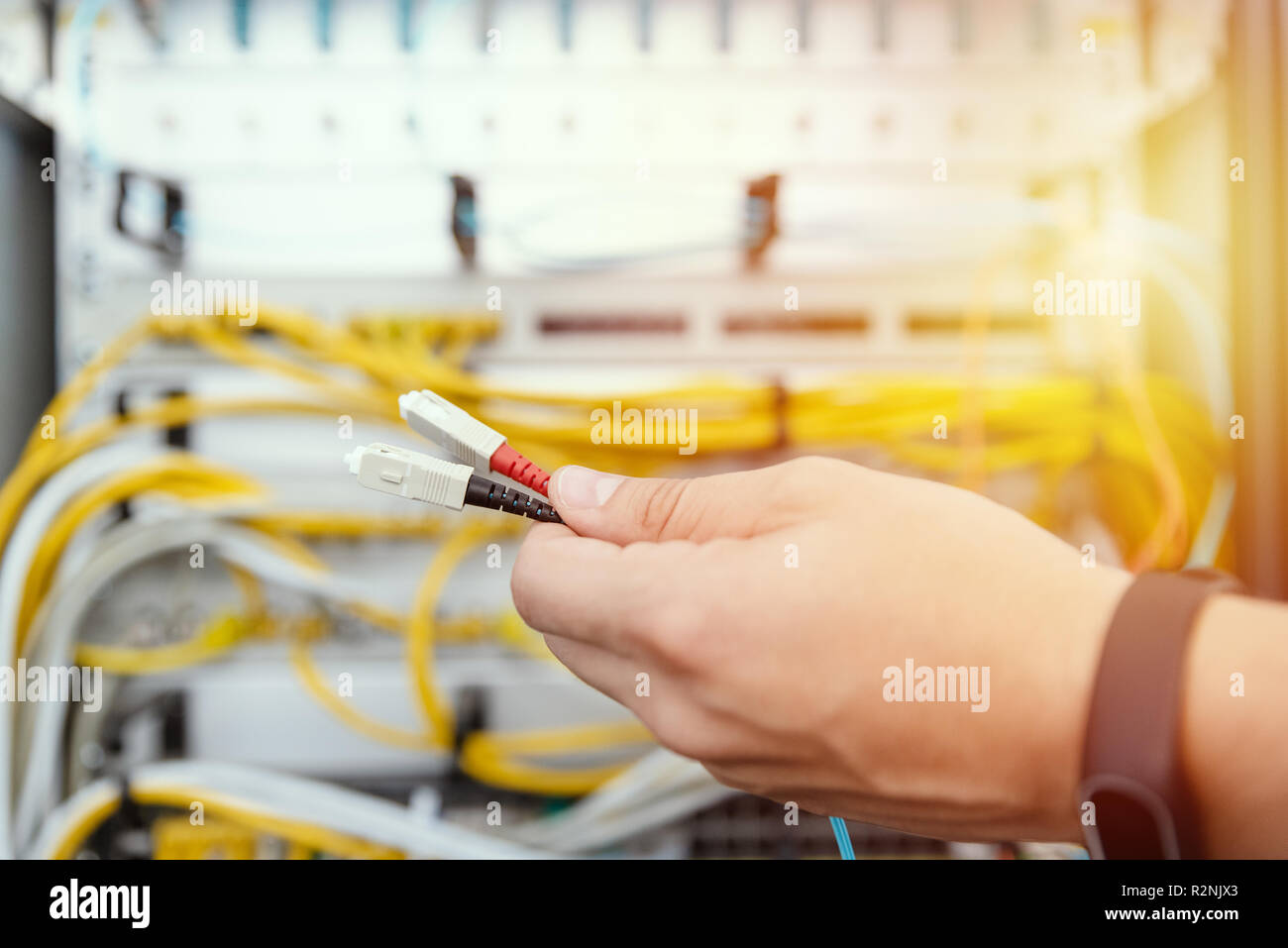 IT specialist connects fiber optic cables to the network equipment. IT