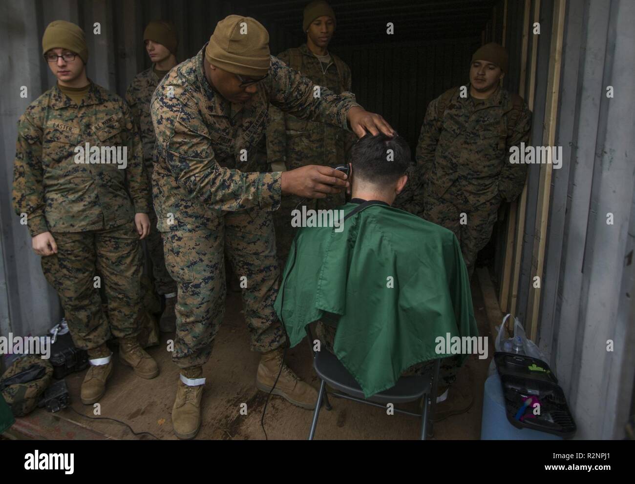 U.S. Marine Corps Sgt. Shaine Phillips with 2nd Intelligence Battalion, II Marine Expeditionary Force Information Group cuts Marines’ hair during Exercise Trident Juncture 18 at Vaernes Air Station, Norway, Nov. 4, 2018. Trident Juncture 18 enhances the U.S. and NATO Allies’ and partners’ abilities to work together collectively to conduct military operations under challenging conditions. Stock Photo