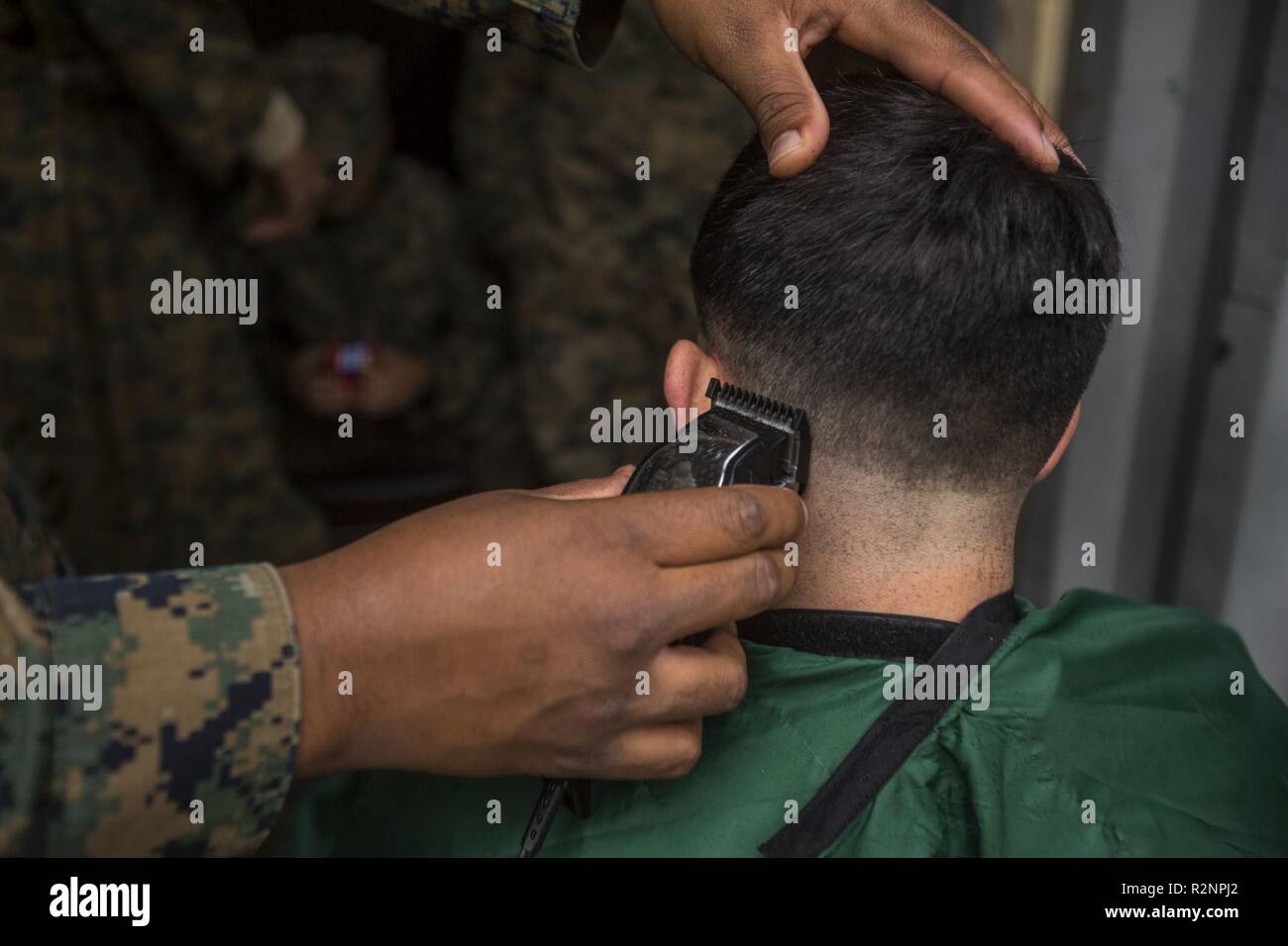 U.S. Marine Corps Sgt. Shaine Phillips with 2nd Intelligence Battalion, II Marine Expeditionary Force Information Group cuts Marines’ hair during Exercise Trident Juncture 18 at Vaernes Air Station, Norway, Nov. 4, 2018. Trident Juncture 18 enhances the U.S. and NATO Allies’ and partners’ abilities to work together collectively to conduct military operations under challenging conditions. Stock Photo