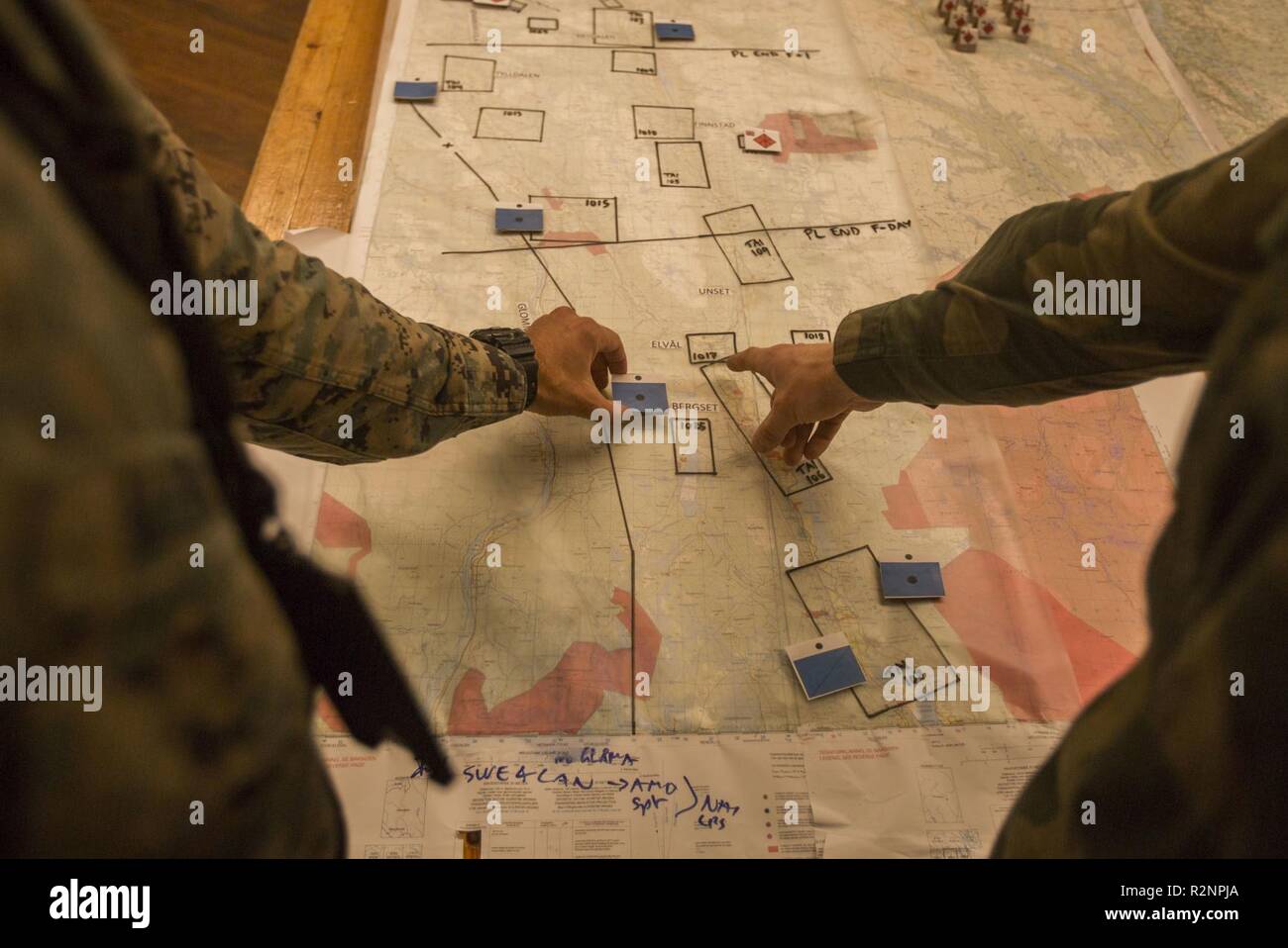 U.S. Marine Corps Maj. Scot Kleinman with Headquarters and Service Battalion, Marine Corps Forces Command looks over a map with a Norwegian Soldier during Exercise Trident Juncture 18 at Glamos, Norway, Nov. 2, 2018. Trident Juncture 18 enhances the U.S. and NATO Allies’ and partners’ abilities to work together collectively to conduct military operations under challenging conditions. Stock Photo