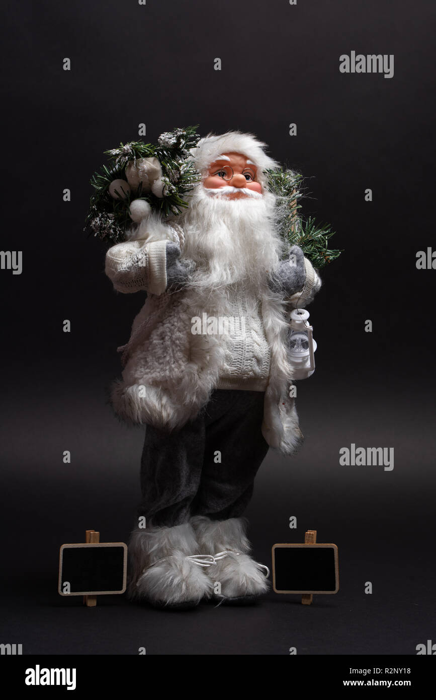 Portrait of Santa Claus toy standing next to two billboard chalk signs. Creative copy space Stock Photo