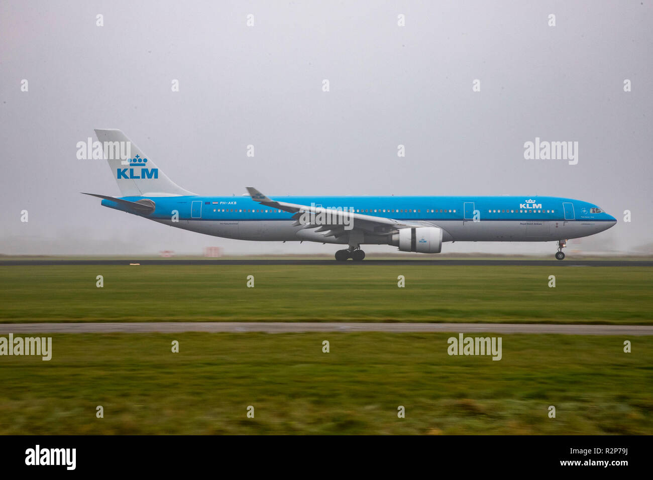 KLM Royal Dutch Airlines Airbus A330-300 with registration PH-AKB landing in misty weather at Amsterdam Schiphol Airport in The Netherlands. The aircraft has the name Piazza Navona - Roma. KLM operates a fleet of 117 airplanes, 13 of them are various editions of Airbus A330. Stock Photo