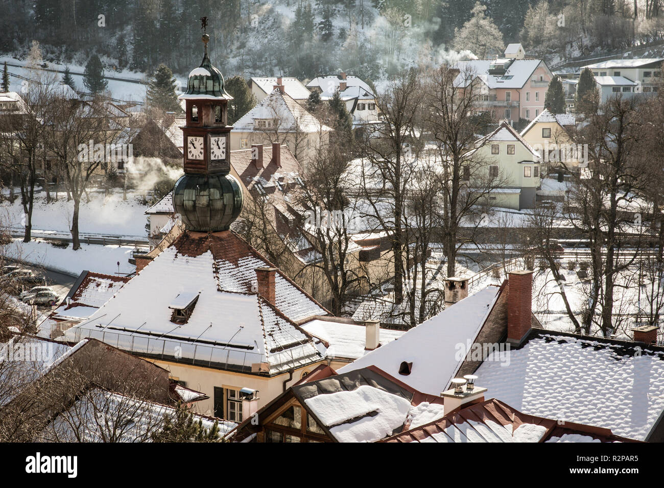 View of snow-covered town houses with smoking chimneys, from above, Murau, on a sunny winter day Stock Photo