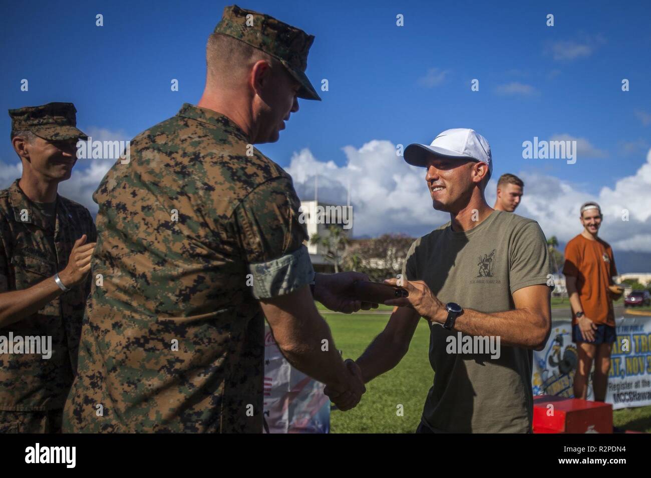 U.S. Marine Corps Sgt. Maj. Mark Shawhan, sergeant major, 3rd Radio Battalion, awards Humberto Baeza, the overall first place winner of the Turkey Trot 10k, during the Turkey Trot 5k and 10k run, Marine Corps Base Hawaii, Nov. 3, 2018. The event, hosted by 3rd Radio Battalion and Marine Corps Community Services Hawaii, is an annual Thanksgiving-themed event that is open to U.S. Service members, their families, and civilian participants. The event promotes readiness and resiliency across the installation and local community by encouraging healthy, family-oriented activity. Stock Photo