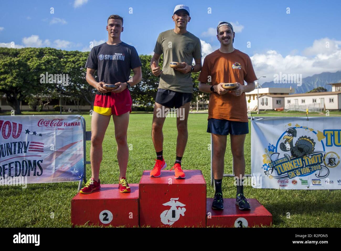 The top three overall winners of the Turkey Trot 10k pose for a group photo during the Turkey Trot 5k and 10k run, Marine Corps Base Hawaii, Nov. 3, 2018. The event, hosted by 3rd Radio Battalion and Marine Corps Community Services Hawaii, is an annual Thanksgiving-themed event that is open to U.S. Service members, their families, and civilian participants. The event promotes readiness and resiliency across the installation and local community by encouraging healthy, family-oriented activity. Stock Photo