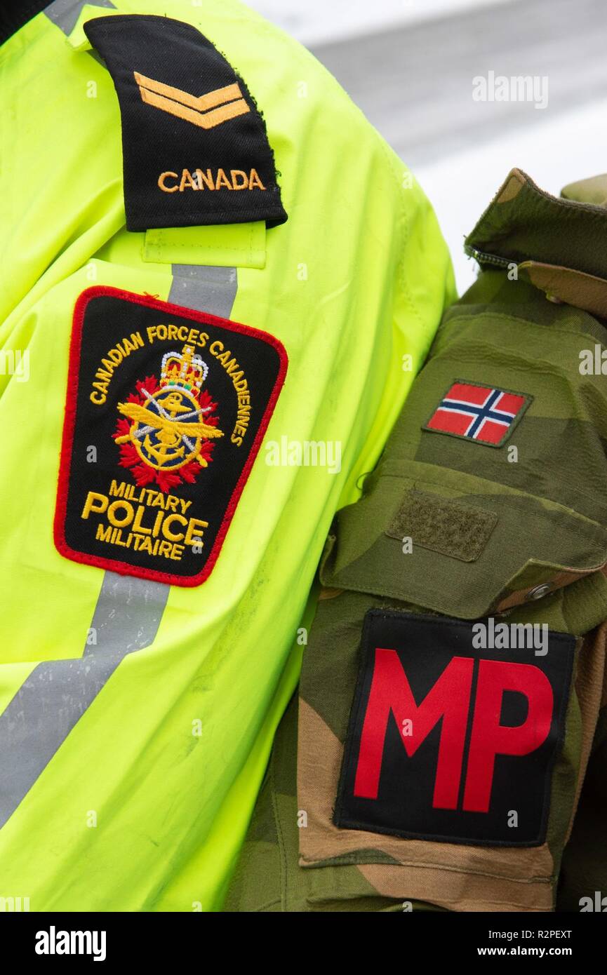 A Canadian Armed Forces Military Police Officer and a Norwegian Military Police Officer compare arm badges while on a patrol near Alvdal, Norway during Exercise TRIDENT JUNCTURE on November 2, 2018.    Trident Juncture 2018 is NATO’s largest exercise in many years, bringing together around 50,000 personnel from all 29 Allies, plus partners Finland and Sweden. Around 65 vessels, 250 aircraft and 10,000 vehicles will participate. Stock Photo