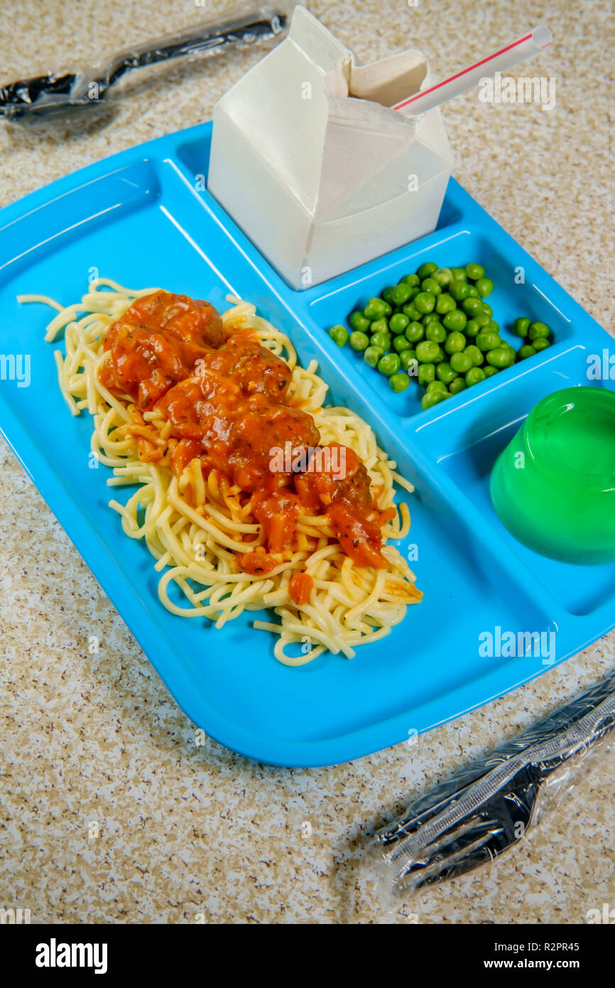 Grade school lunch tray of Italian spaghetti and meatballs with green