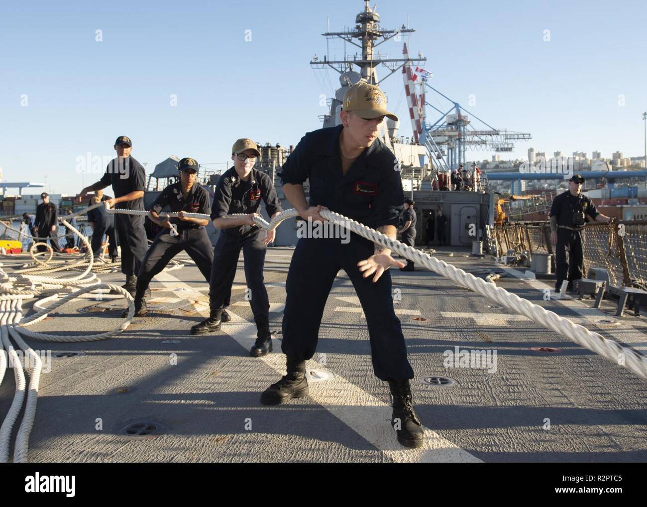 HAIFA, Israel (Oct. 28, 2018) Sailors heave a mooring line aboard the Arleigh Burke-class guided-missile destroyer USS Arleigh Burke (DDG 51) as the ship departs Haifa, Israel, following a scheduled port visit Oct. 28, 2018. Arleigh Burke, homeported at Naval Station Norfolk, is conducting naval operations in the U.S. 6th Fleet area of operations in support of U.S. national security interests in Europe and Africa. Stock Photo