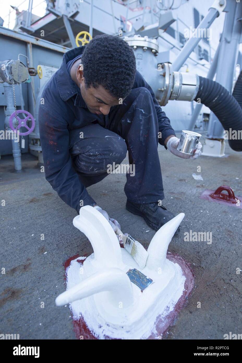 MEDITERRANEAN SEA (Oct. 29, 2018) Boatswain’s Mate 3rd Class Erick Anderson paints a deck fixture aboard the Arleigh Burke-class guided-missile destroyer USS Arleigh Burke (DDG 51) in the Mediterranean Sea Oct. 29, 2018. Arleigh Burke, homeported at Naval Station Norfolk, is conducting naval operations in the U.S. 6th Fleet area of operations in support of U.S. national security interests in Europe and Africa. Stock Photo